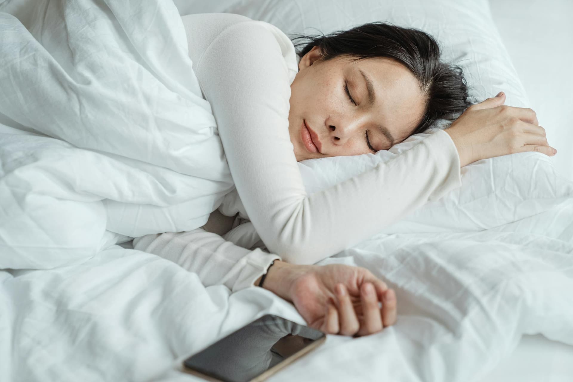 Person sleeping peacefully with iPhone on nightstand