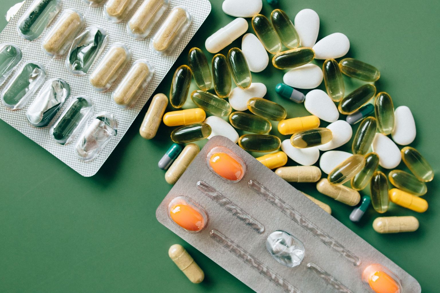 Tablets, capsules and blister packs on a green background - exporting a medication list from Apple Health