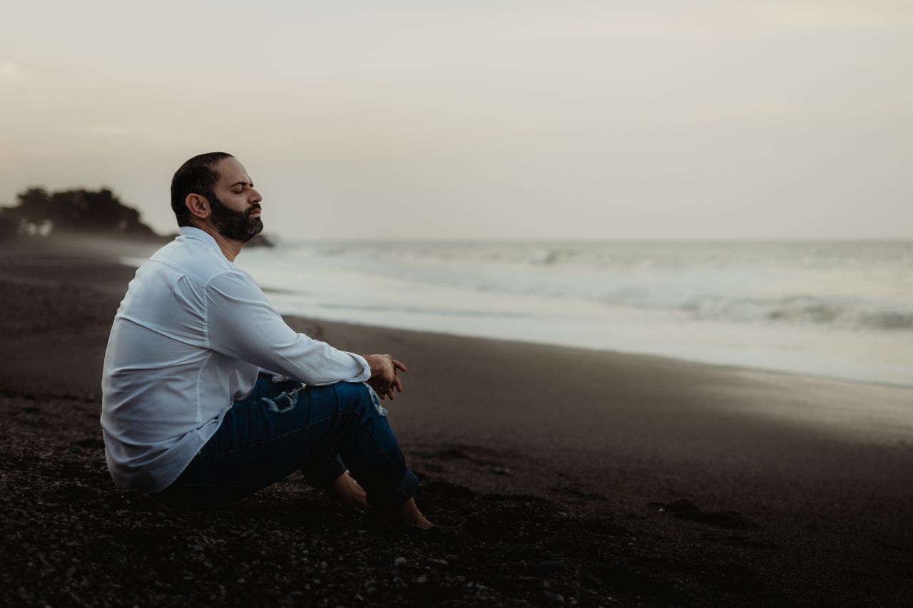 Person meditating peacefully on a quiet beach - mental health and State of Mind tracking with Apple Health